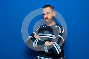 Profile side view portrait of nice attractive virile brunet guy folded arms copy space isolated over blue color