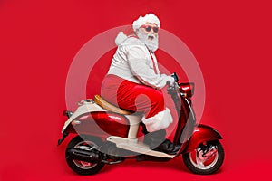 Profile side view portrait of nice bearded cheerful cheery funny Santa father riding motor bike having fun shopping