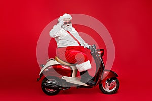 Profile side view portrait of nice bearded confused amazed funny funky Santa riding moped hurry up cool winter season