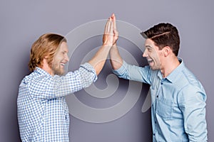 Profile side view portrait of two nice attractive glad cheerful cheery guys best buddy fellow clapping palms deal done