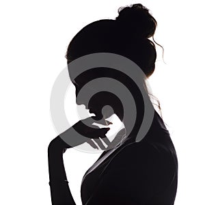 Profile silhouette of a pensive girl with a hand at the chin, a young woman lowered her head down on a white isolated background