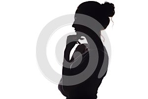 Profile silhouette of a pensive girl with a hand at the chin, a young woman on a white isolated background