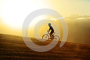 Profile silhouette sport man cycling uphilll riding cross country mountain bike photo