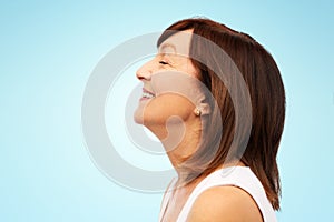 Profile of smiling senior woman over blue