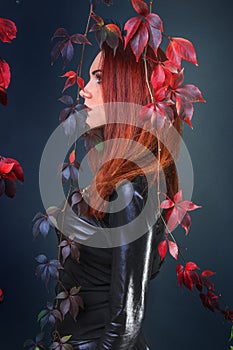 Profile of a tall red head gothic woman among the autumn vines