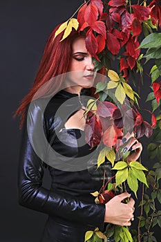 Profile of a tall red head gothic woman among the autumn vines