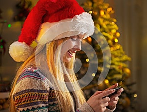 Profile teenager girl in santa hat writing sms