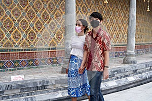 Profile of a transsexual couple visiting a buddhist temple while holding hands