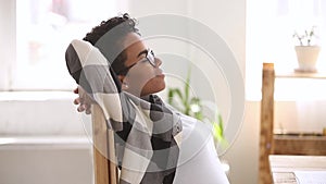 Profile view african woman accomplished work stretching resting on chair