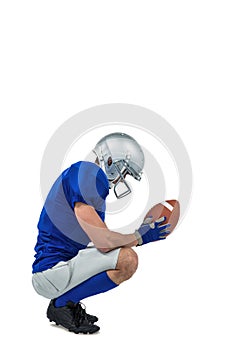 Profile view of American football player in attack stance