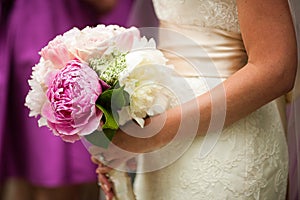 Profile view of bride holding wedding bouquet of flowers