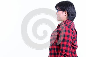 Profile view of happy overweight Asian hipster woman smiling