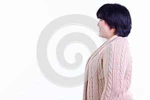 Profile view of happy overweight Asian woman smiling ready for winter