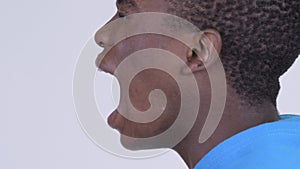 Profile view of mouth of young African man shouting