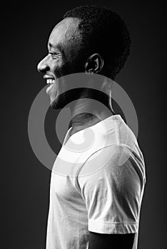 Profile view portrait of young African man smiling in black and white