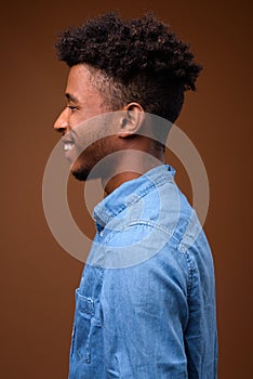 Profile view portrait of young handsome African man smiling