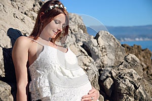 Profile view of pregnant woman on the beach
