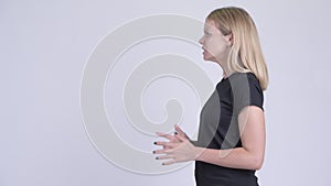 Profile view of young angry blonde woman talking and complaining