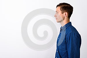 Profile view of young handsome man against white background