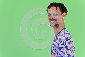 Profile view of young happy African man smiling and looking at camera