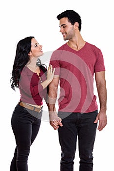 Profile view of young happy couple smiling while holding hands a