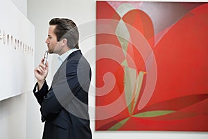 Profile view of a young man in a art art gallery