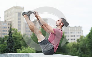 Profile view of young man doing boat pose