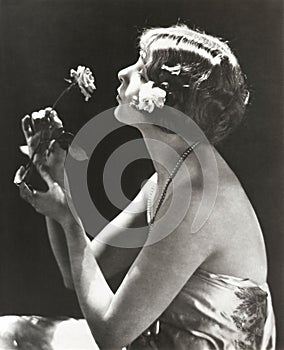 Profile view of young woman smelling flower