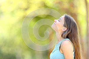 Profile of a woman breathing fresh air in a forest photo