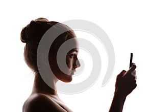 Profile woman in a shade of a silhouette with phone, isolated o