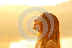 Profile of a woman at sunset breathing fresh air