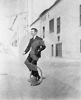 Profile of a young man riding a unicycle photo