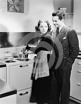 Profile of a young woman cooking food with a young man