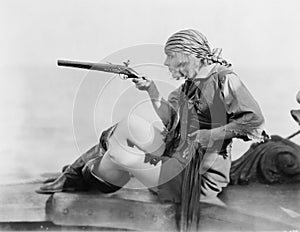 Profile of a young woman holding a flintlock pistil in a pirates outfit