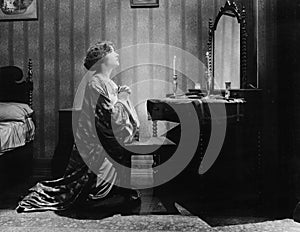 Profile of a young woman pleading in front of a mirror in her bed room photo