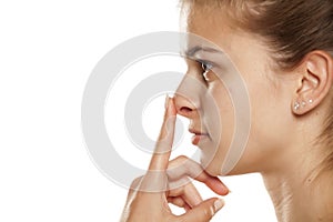 Profile of young woman touching her nose