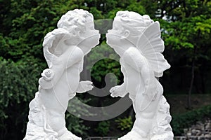Profiles of kissing cherubs in park