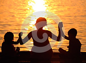 Profiles of mother and children at sunset