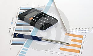Profit bar chart, pen, notepad and calculator