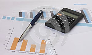 Profit bar chart, pen, notepad and calculator