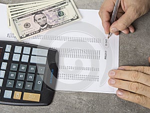 Profit and loss concept image of a pen, calculator and coins on financial documents