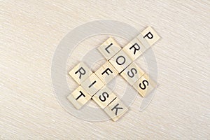 Profit, loss and risk crossword blocks on table. Top view