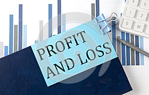 PROFIT AND LOSS on sticky note on notebook on the chart background