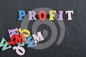 PROFIT word on black board background composed from colorful abc alphabet block wooden letters, copy space for ad text. Learning