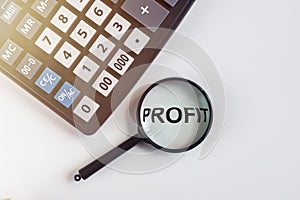 PROFIT word on table through magnifying glass, business concept