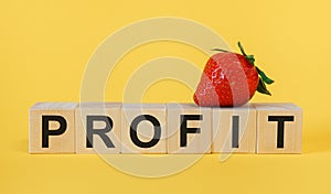 PROFIT- word wooden cubes on yellow background