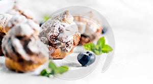 Profiterole or cream puff with filling, powdered sugar topping with berries, isolated on white background