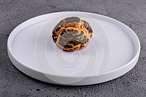 A profiterole, french choux pastry covered chocolate chips