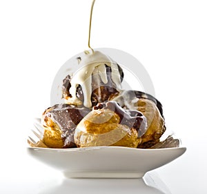 Profiteroles with hot chocolate and cream