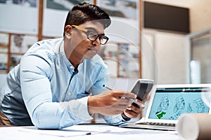 Profiting from his passion for design. a young architect using a calculator while drawing up a building plan.